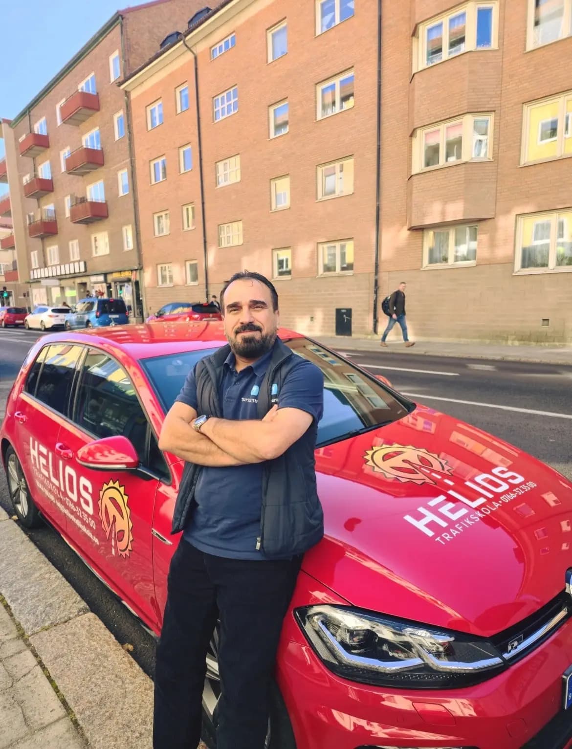 Hamid, trafiklärare på Helios Trafikskola, vid övningsbilen i Eskilstuna